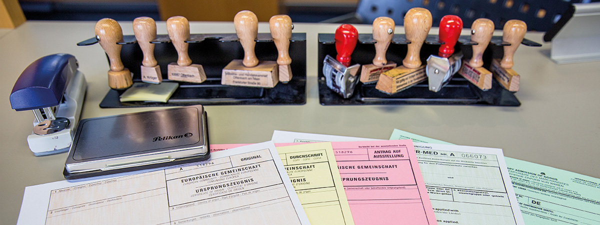 Vier farbige Formulare und Stempel auf einem Tisch