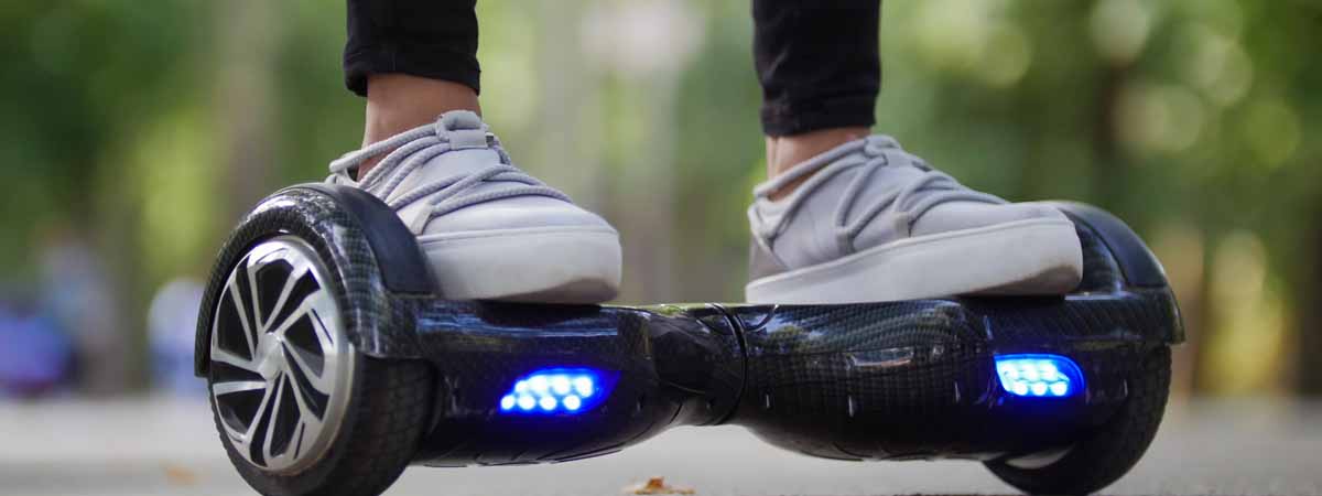 Female legs in sneakers on the steep gyrometer. Riding in the park.